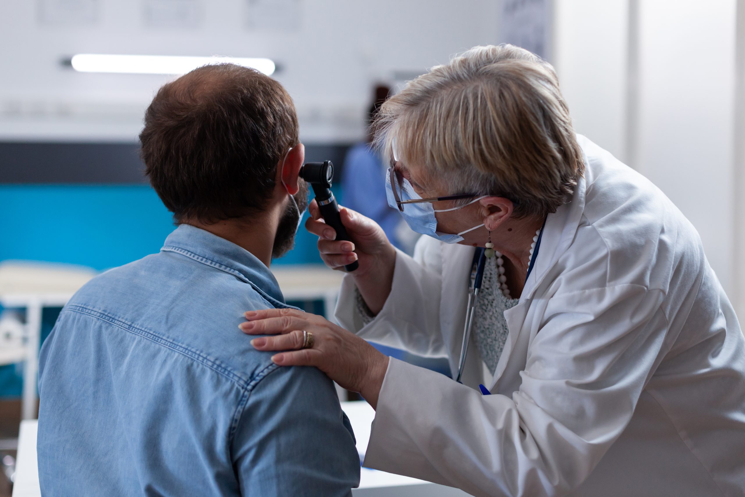 Close up of physician using otoscope to do ear consultation with patient Close up of physician using otoscope to do ear consultation with patient. Woman otologist checking infection with otolaryngology instrument at medical visit during coronavirus pandemic.