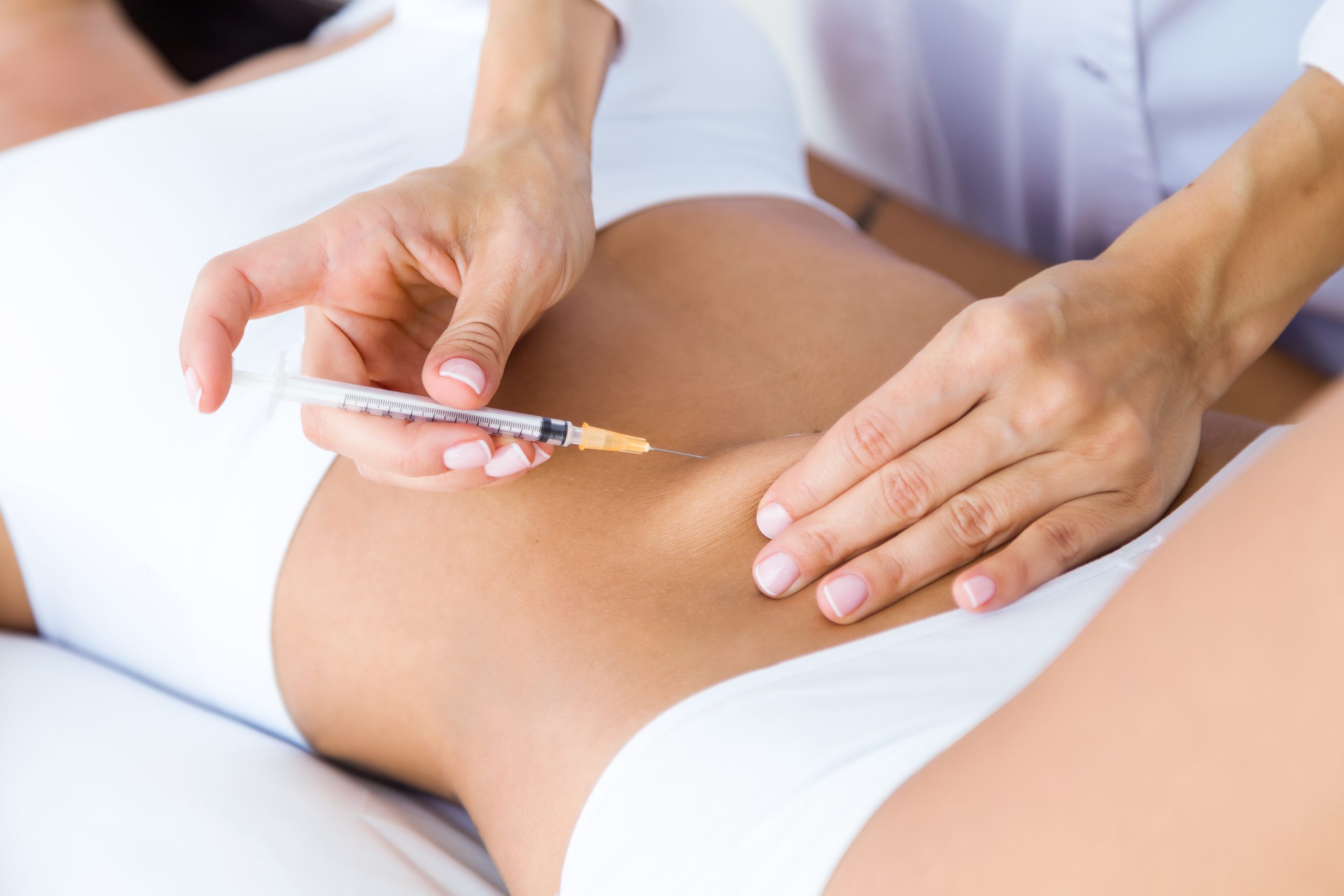 Surgeon making injection into female body. Liposuction concept. Portrait of surgeon making injection into female body. Liposuction concept.