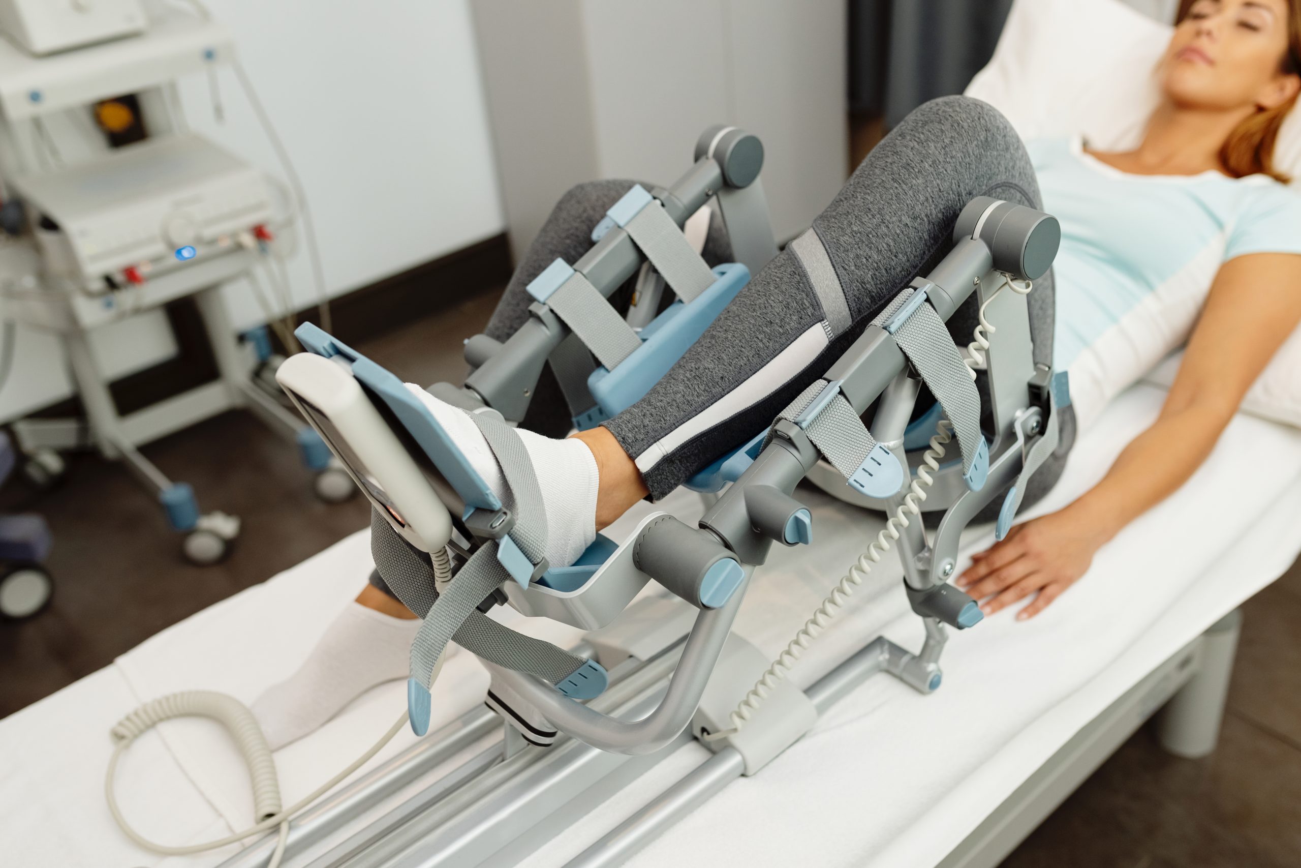 Close-up of woman during physical rehabilitation with arthromot Close-up of woman receiving leg treatment with kinetek device at health spa.